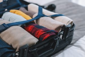 packing suitcase for traveling to boston in winter with warm clothes thanks to tips from travel experts at maverick suites